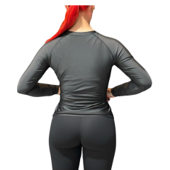 Naisten pitkähihainen Lady Tac Rashguard -kompressiopaita kuvattuna edestä tasaisella taustalla. Paidassa on urheilullinen, naisen vartaloa myötäilevä leikkaus, tactical-henkinen muotoilu ja laadukkaat tasosaumat. Suunniteltu kamppailulajeihin ja treeniin.